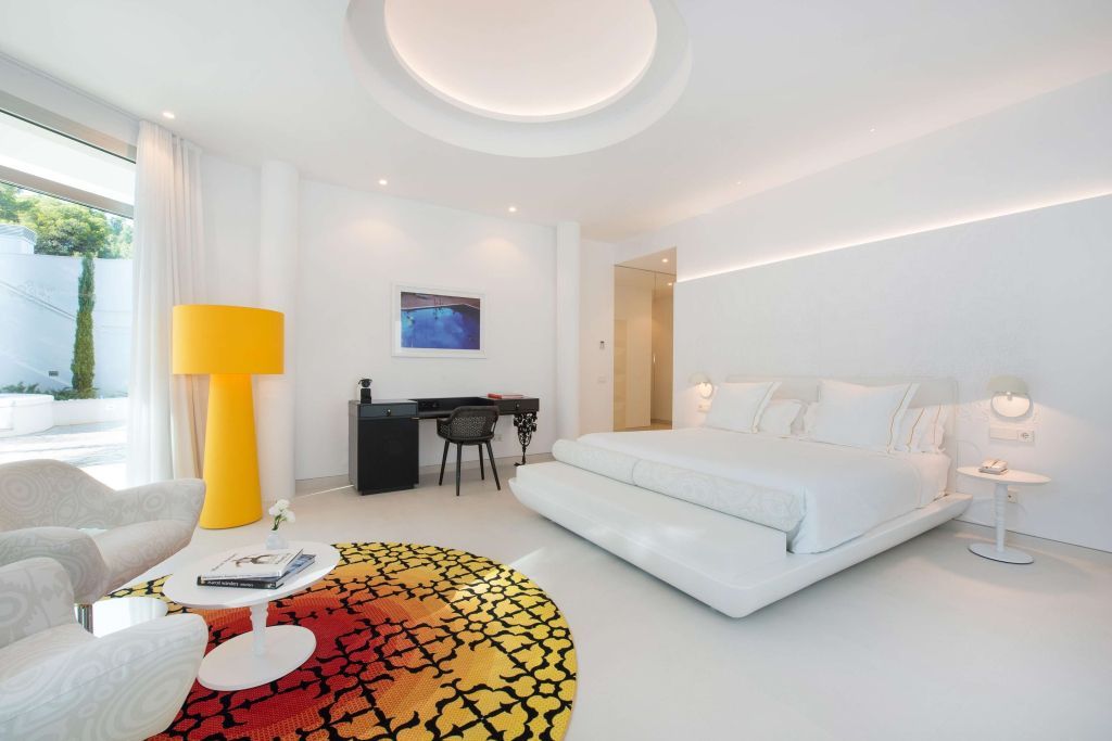 Helle Junior-Suite mit modernem Design, gelbem Teppich und Schreibtisch