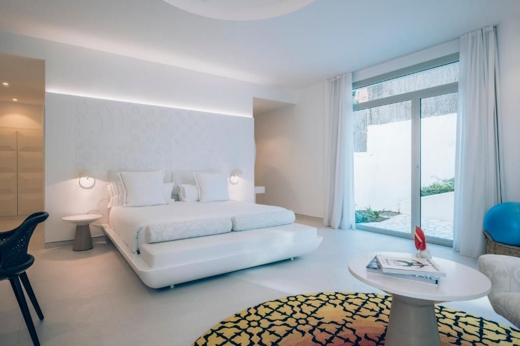 Helles Schlafzimmer mit Doppelbett und Zugang zur Terrasse in der Spa Suite