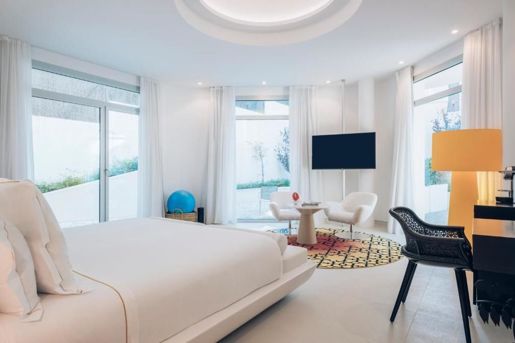 Raum mit Doppelbett, Sitzbereich und großen Fenstern in der Spa Suite