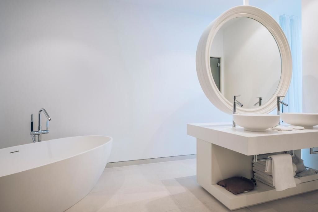 Bad mit freistehender Badewanne und rundem Spiegel in der Spa Suite