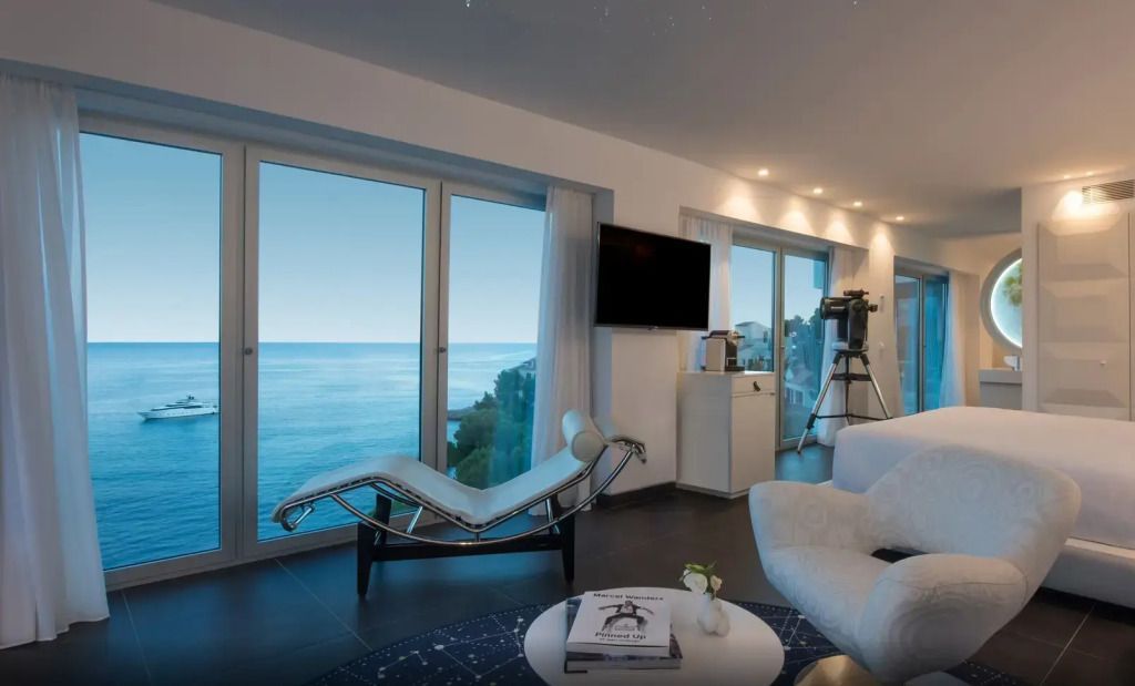 Moderne Lounge mit Meerblick und Teleskop für Sternenbeobachtung.