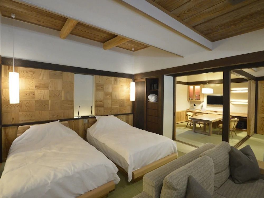 Deluxe Doppelzimmer in warmen Holztönen mit zwei Einzelbetten und gemütlicher Sitzecke