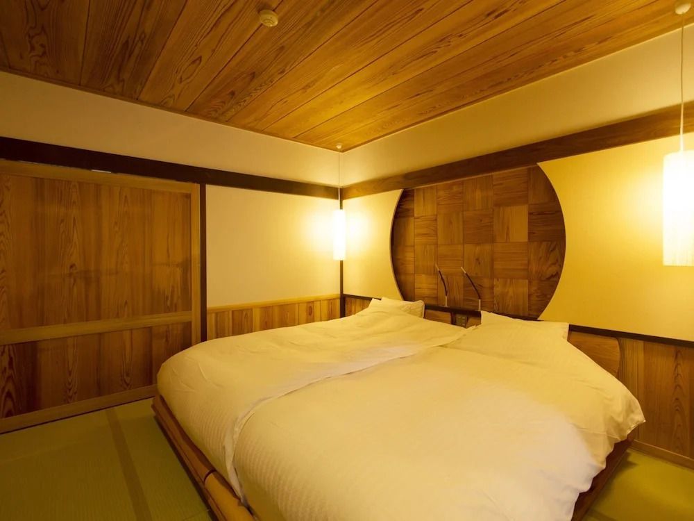 Großes Doppelbett in einem Raum mit eleganten Holzakzenten.