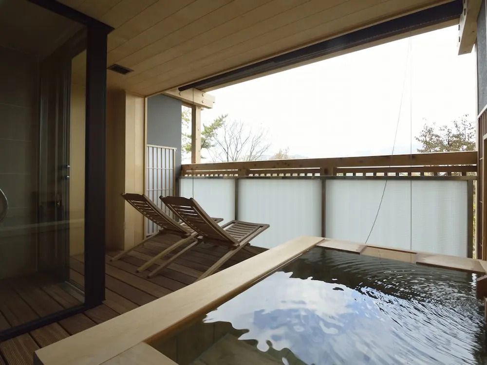 Balkon mit zwei Liegestühlen und einem privaten Onsen.