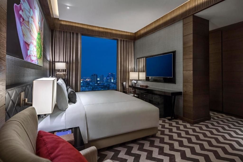 Luxuriöses Schlafzimmer mit Doppelbett und Stadtblick bei Nacht