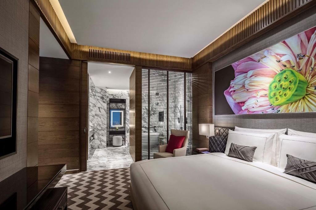 Elegantes Schlafzimmer mit moderner Kunst und Badezimmereingang