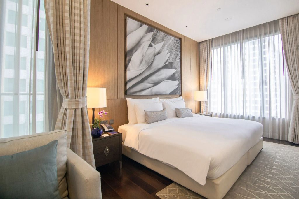 Elegant eingerichtetes Schlafzimmer mit Doppelbett und großer Kunst an der Wand