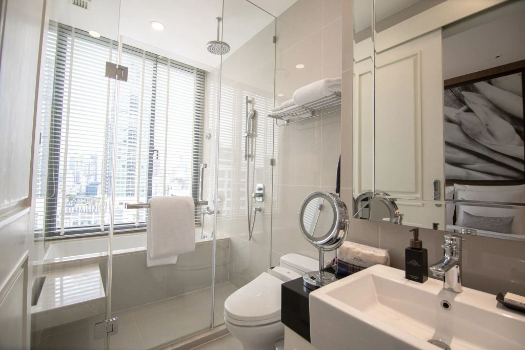Helles Badezimmer mit Glasdusche und großen Fenstern
