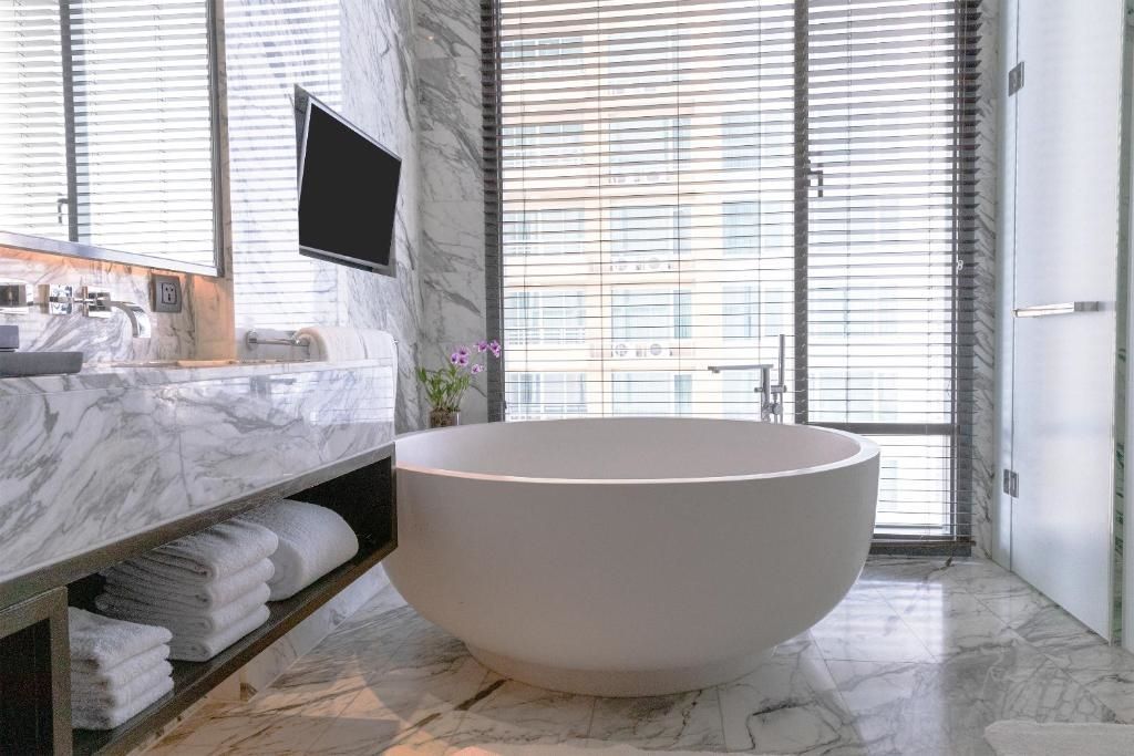 Luxuriöses Badezimmer mit freistehender Badewanne und Marmordesign in der Rattanakosin Suite.