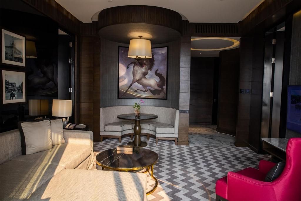 Gemütliche Sitzecke mit Kunstbild in der eleganten Rattanakosin Suite.