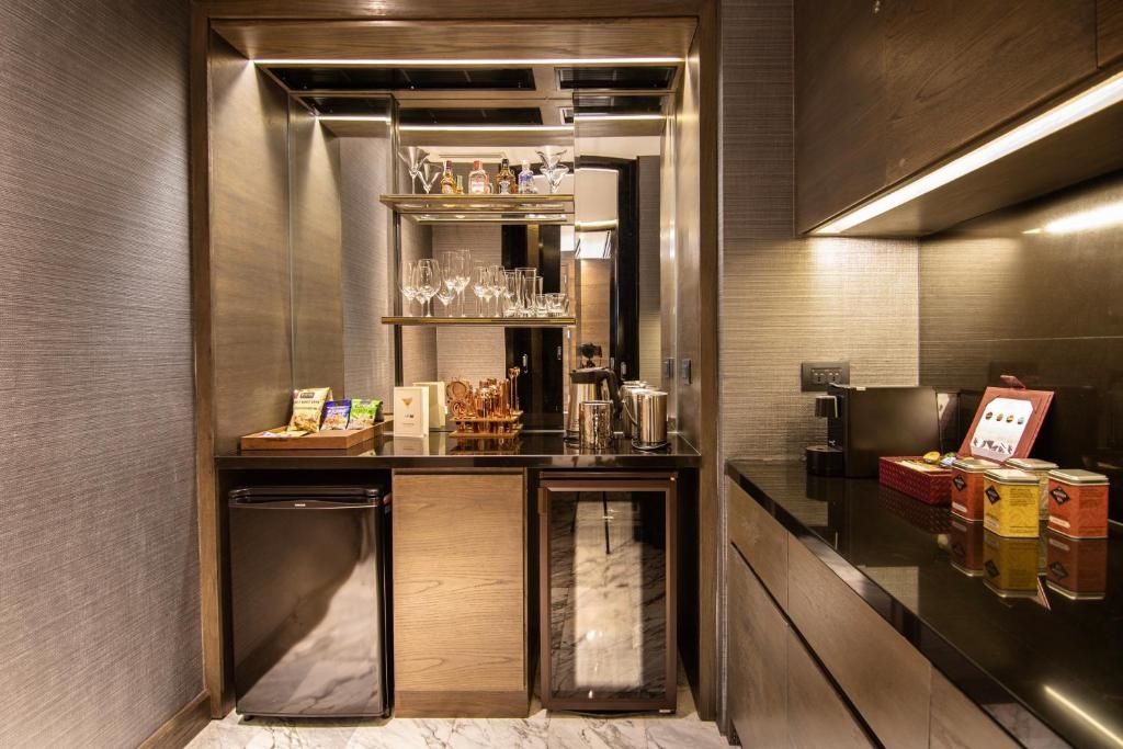 Moderne Minibar in der Sukhothai Suite mit Glasregal und Snacks.