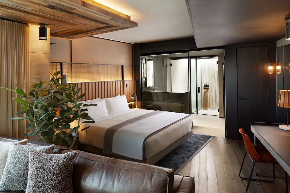 Moderne Suite mit großem Bett und Glasdusche im 1 Hotel Brooklyn Bridge