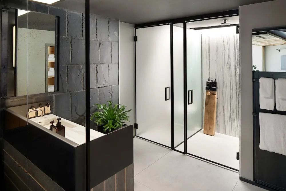 Elegantes Badezimmer mit Glaswand und Pflanzenakzent