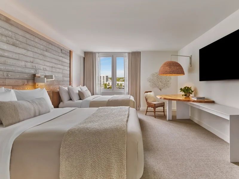 Geschmackvoll eingerichtetes Schlafzimmer mit zwei Betten und Stadtblick.