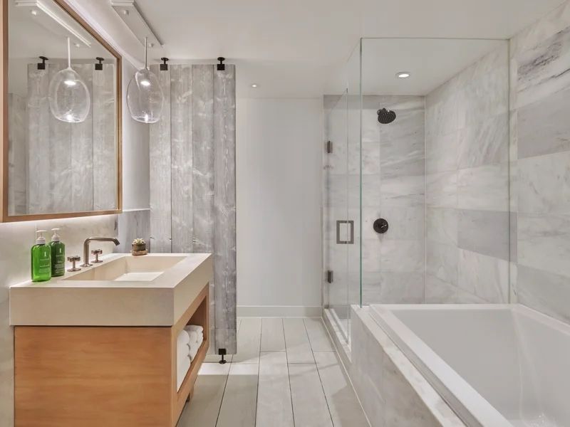 Luxuriöses Badezimmer in Marmoroptik mit Badewanne und Doppelwaschbecken