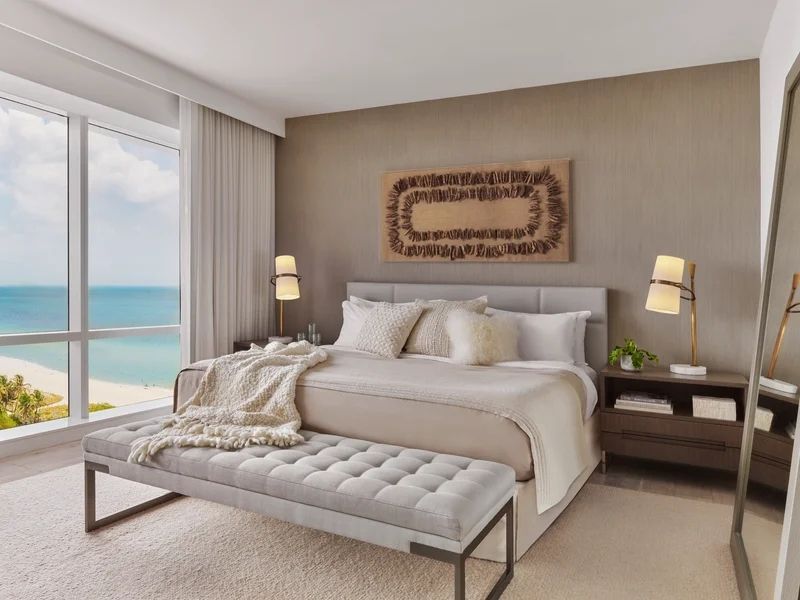 Elegantes Schlafzimmer mit Kingsize-Bett, beleuchtetem Kunstwerk und Meerblick.