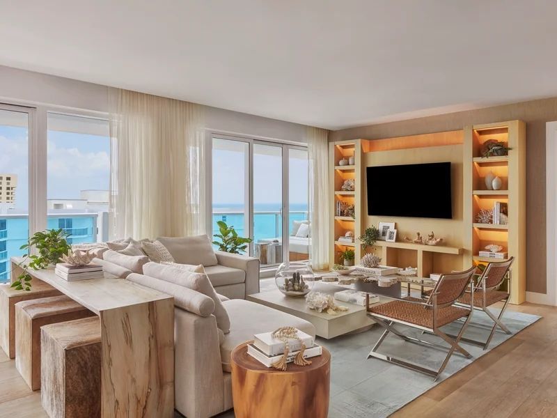 Wohnzimmer mit Meerblick, gemütlichen Sofas und dekorativen Regalen.