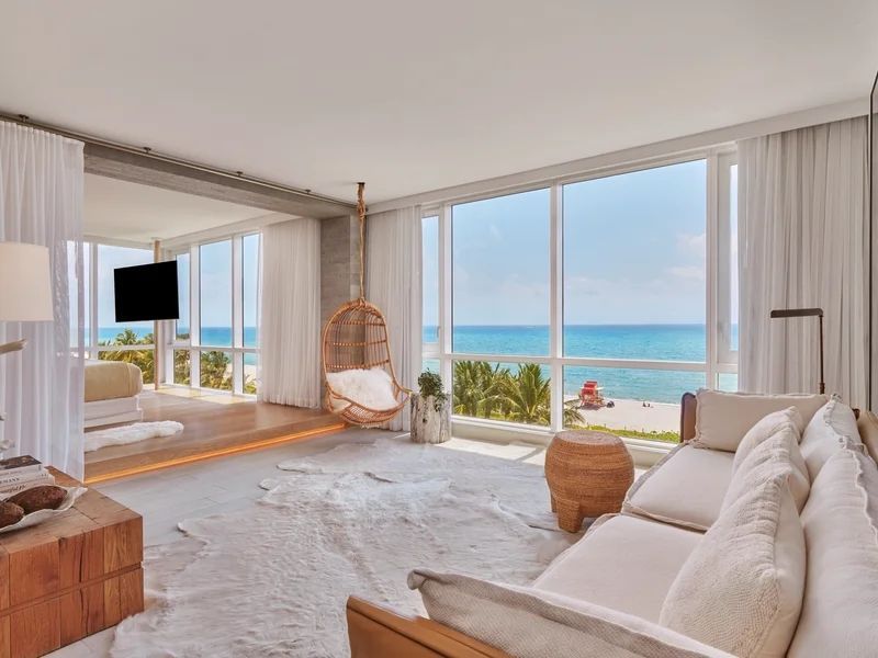 Heller Loungebereich mit Panoramablick auf das Meer und Schaukelstuhl