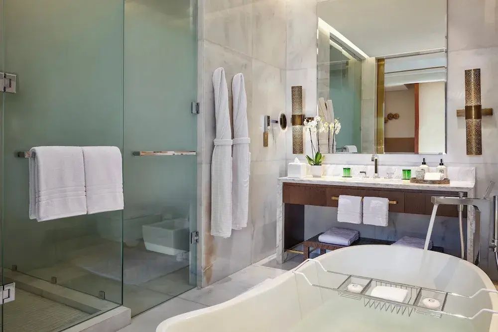 Modernes Badezimmer mit freistehender Badewanne, Glasdusche und Waschtisch.