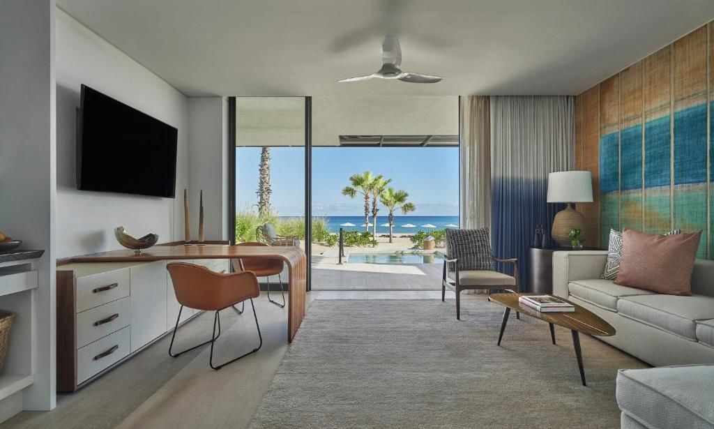 Wohnbereich eines Hotelzimmers mit Schreibtisch, Sessel und Blick auf den Strand