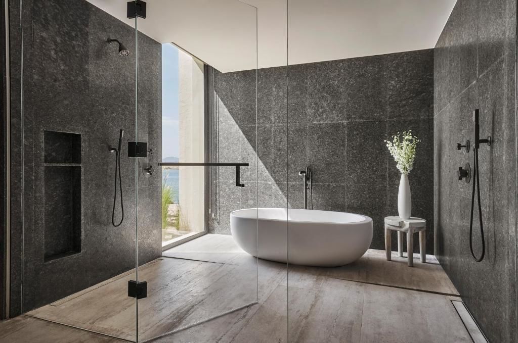 Badezimmer mit dunkler Wand, freistehender Badewanne und Dusche.