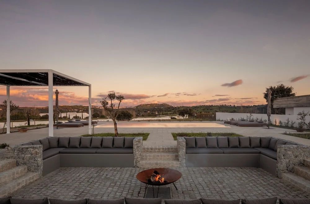 Terrasse mit einer Feuerschale, Sitzgelegenheiten und Blick auf die Landschaft.