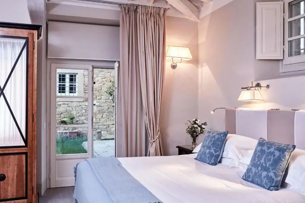 Schlafzimmer mit Doppelbett und Ausgang zu einer kleinen Terrasse.