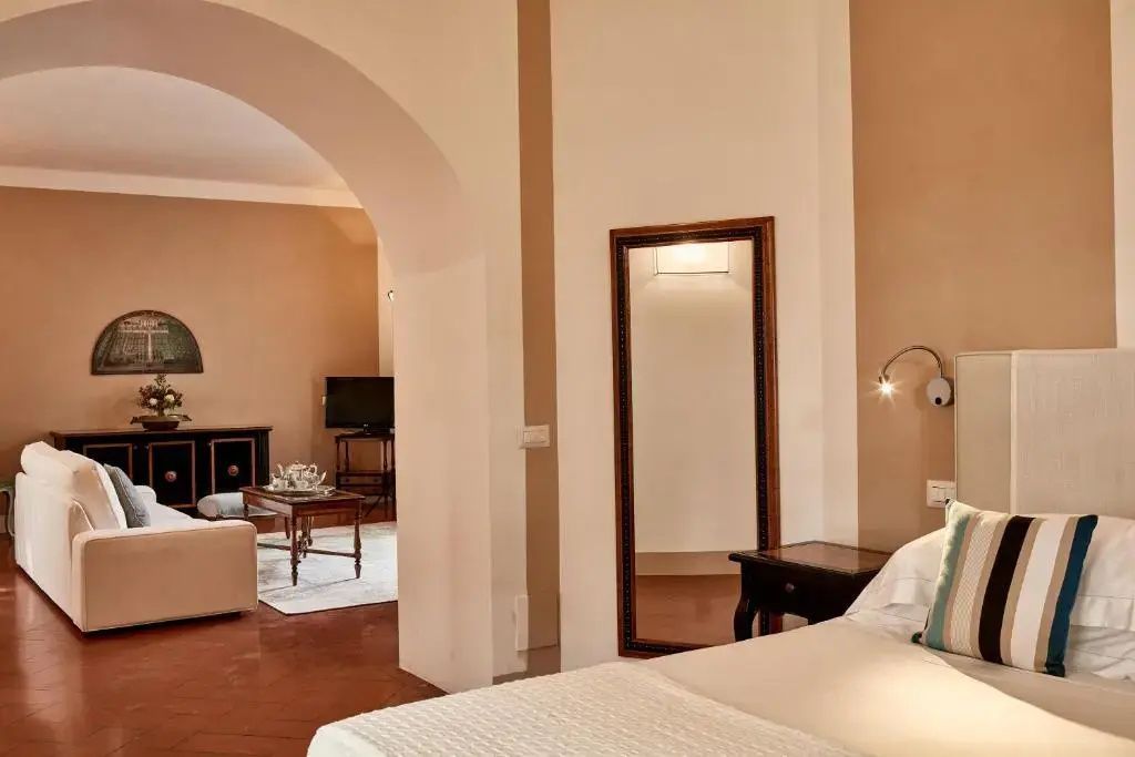 Geräumige Suite mit Rundbogen zwischen Schlafbereich und Wohnzimmer.