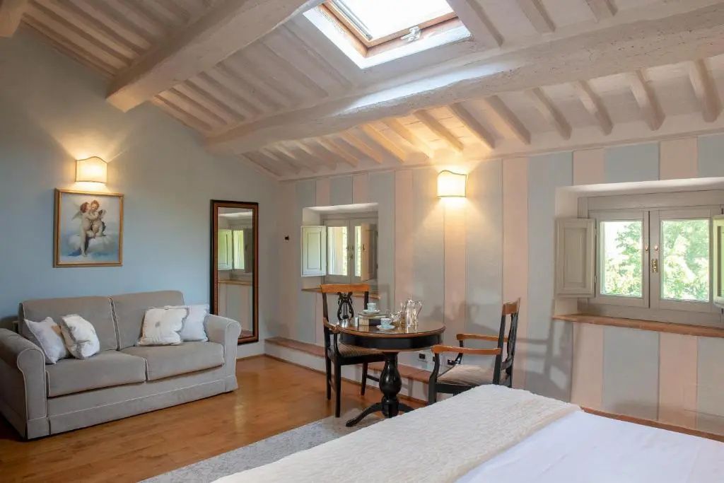 Sitzbereich im Zimmer mit rundem Tisch, Stühlen, Sofa und Dachfenster.