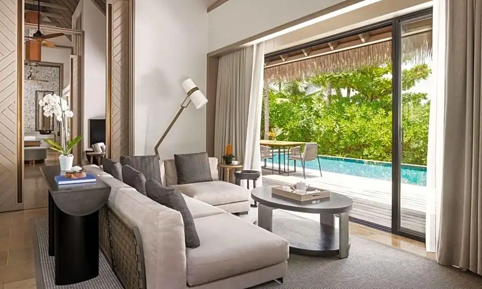Blick aus dem Wohnbereich einer Villa auf die Terrasse und den privaten Pool im Außenbereich.