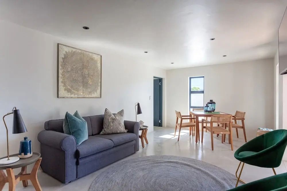 Wohnbereich mit grauem Sofa und Esstisch in modernem Apartment