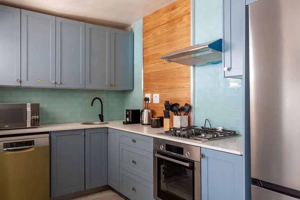 Moderne Küche mit blauen Schränken und Holzakzenten