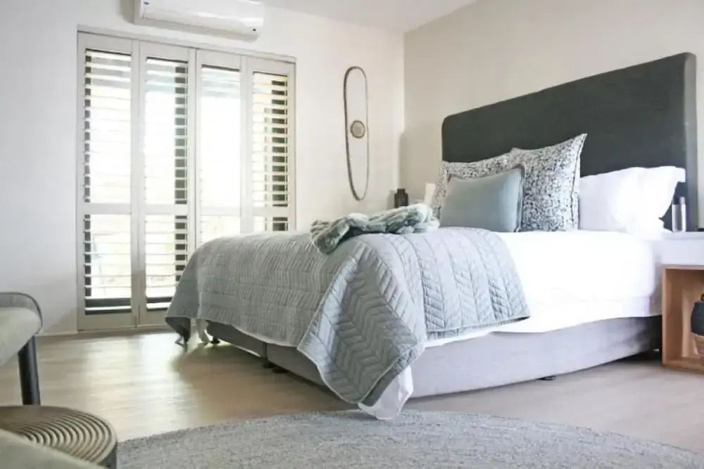 Schlafzimmer mit großem Bett und Accessoires in sanften Farben