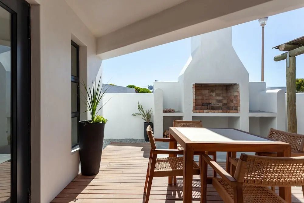 Terrasse mit Holztisch und eingebautem Grillkamin