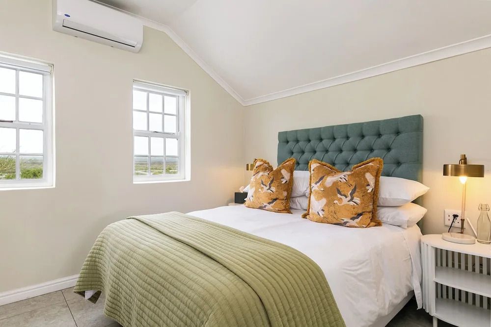 Helles Schlafzimmer mit Doppelbett und Fenster mit Aussicht