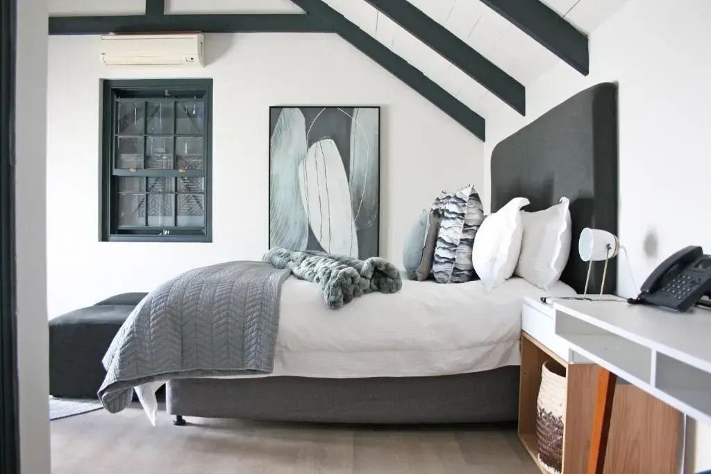 Komfortables Doppelbett in stilvoll eingerichteter Suite mit schräger Decke