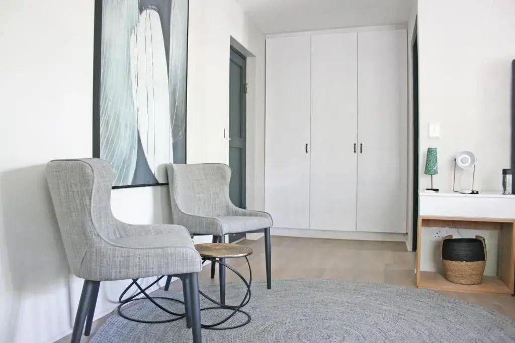 Elegante Flurecke mit zwei Stühlen und großem Kunstwerk