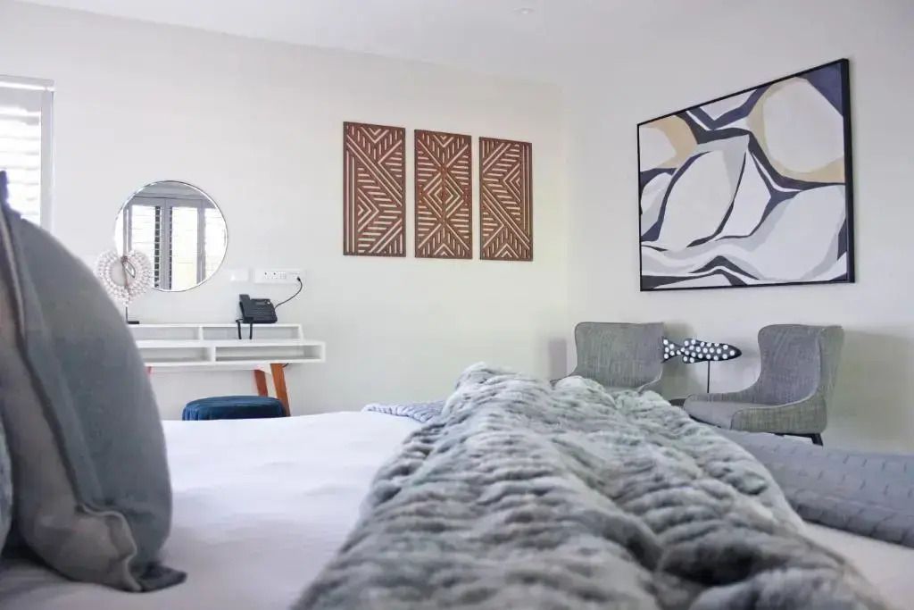 Blick über das Bett in modern eingerichtetes Luxuszimmer mit Wandkunst