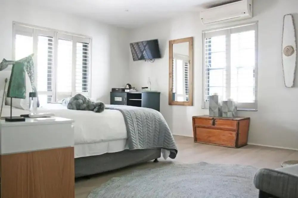 Geräumiges Zimmer mit Bett, Fensterläden und TV
