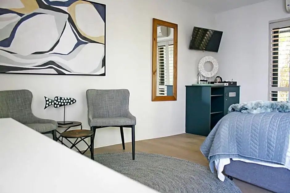 Komfortables Zimmer mit Sessel, Kunstwerk und moderner Einrichtung