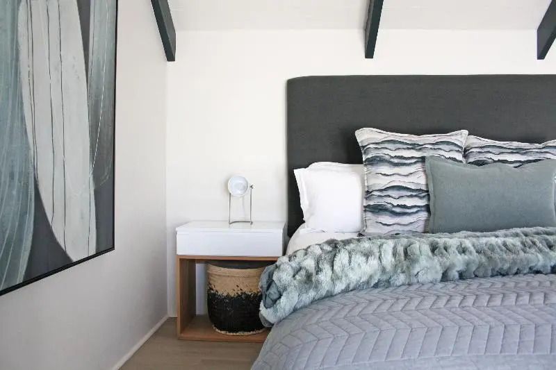 Modernes Zimmer mit gemütlichem Bett und stilvollem Nachttisch im Abalone Hotel