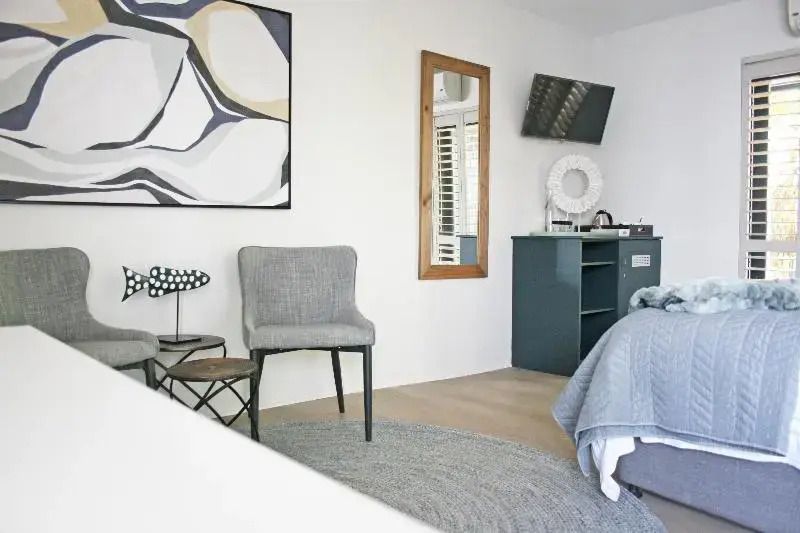 Sitzecke mit moderner Kunst und kleinem Tisch im Abalone Hotel Studio