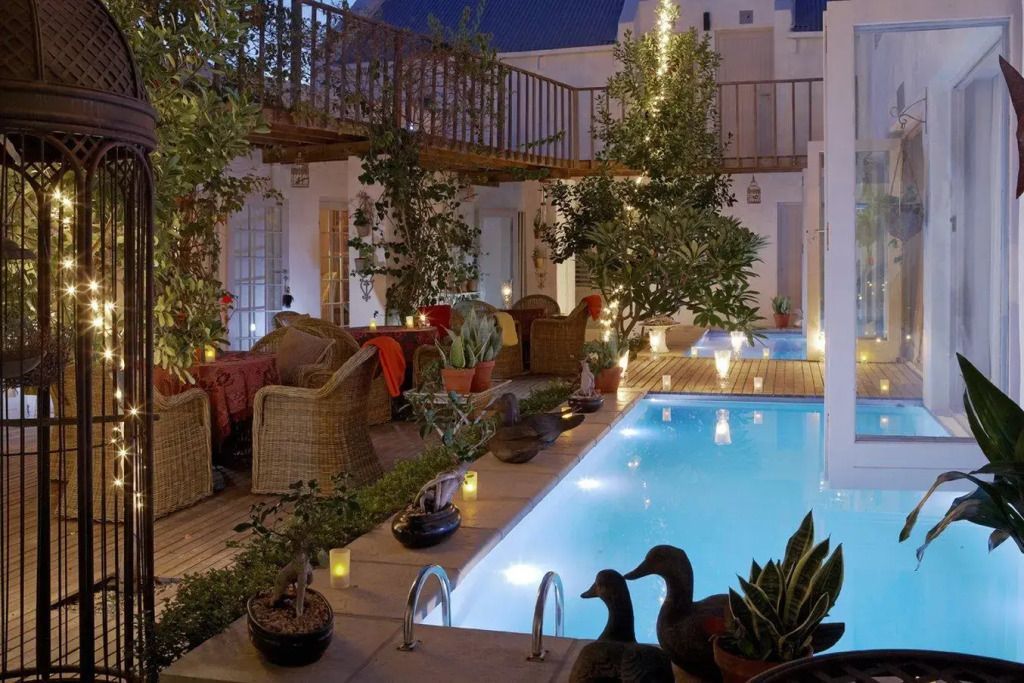Beleuchteter Innenhof mit Pool und Pflanzen im Abalone Hotel