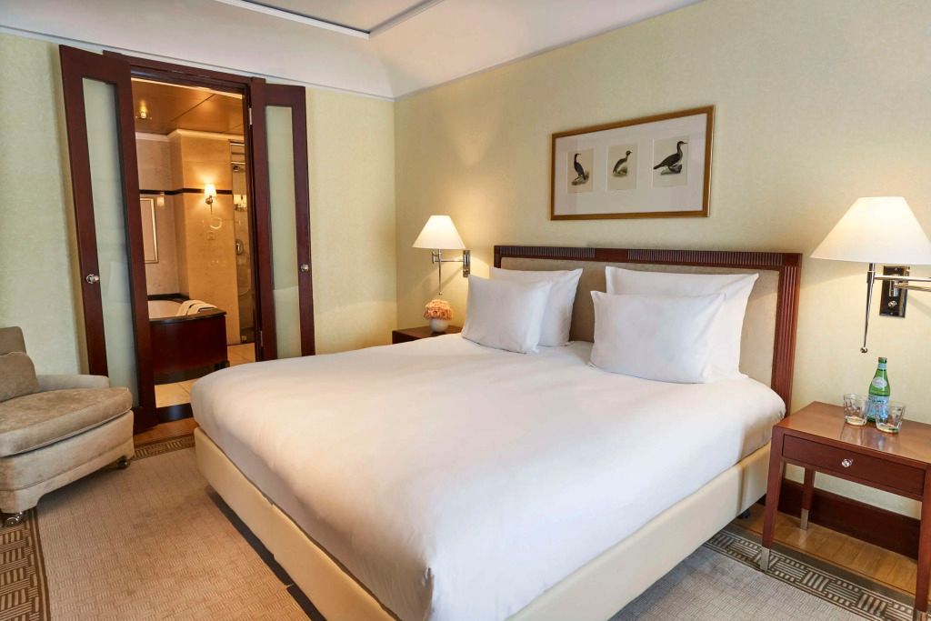 Helles Schlafzimmer mit großem Doppelbett und moderner Einrichtung