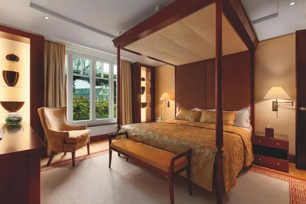 Elegantes Schlafzimmer der Berlin Suite mit Himmelbett und großen Fenstern