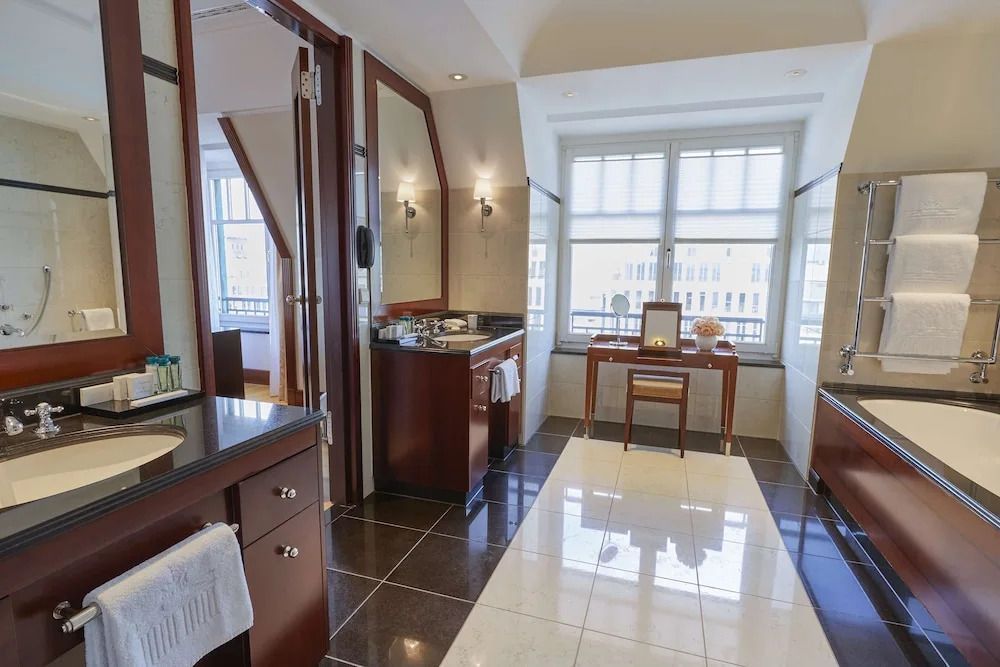 Helles Badezimmer mit großem Fenster und zwei Waschbecken in der Deluxe Suite