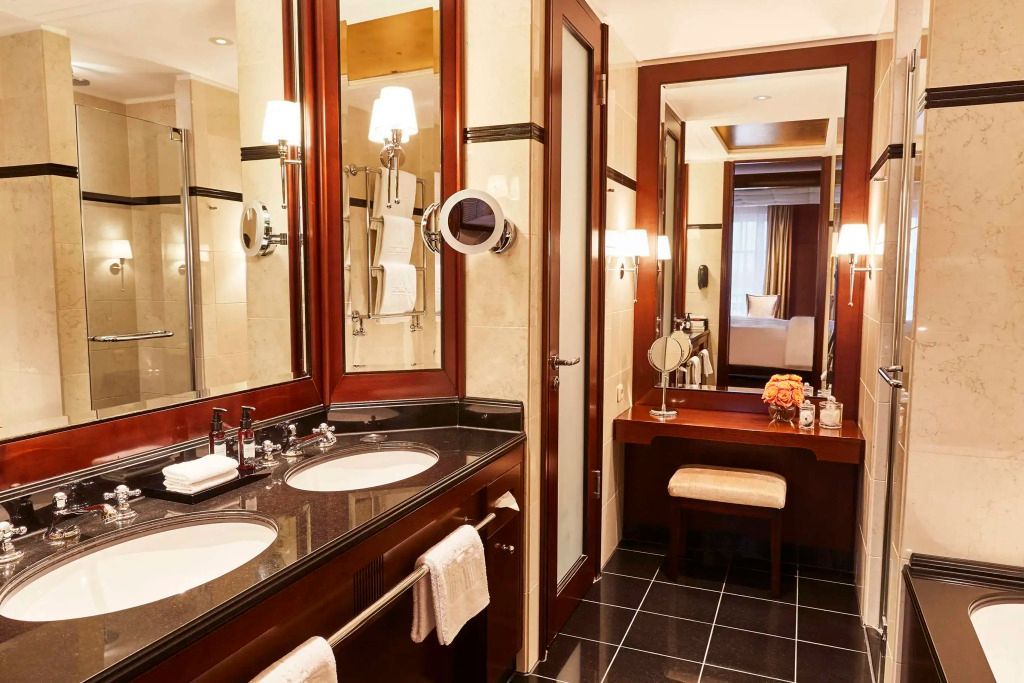 Elegantes Badezimmer mit Doppelwaschbecken und Spiegel in der Junior-Suite