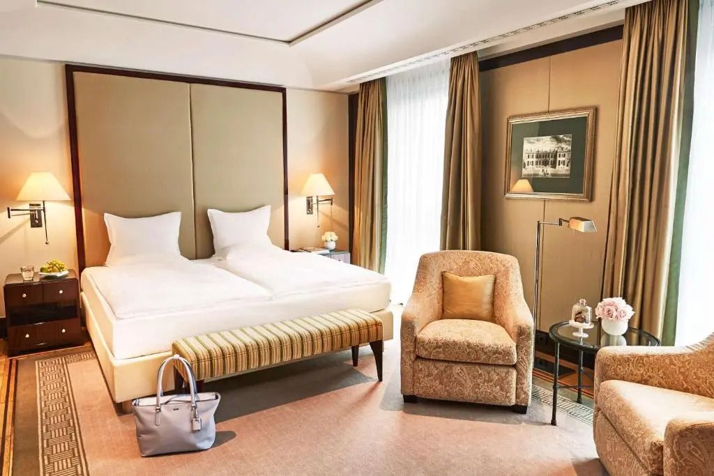 Helles, luxuriöses Doppelzimmer mit Doppelbett und eleganter Sitzgelegenheit
