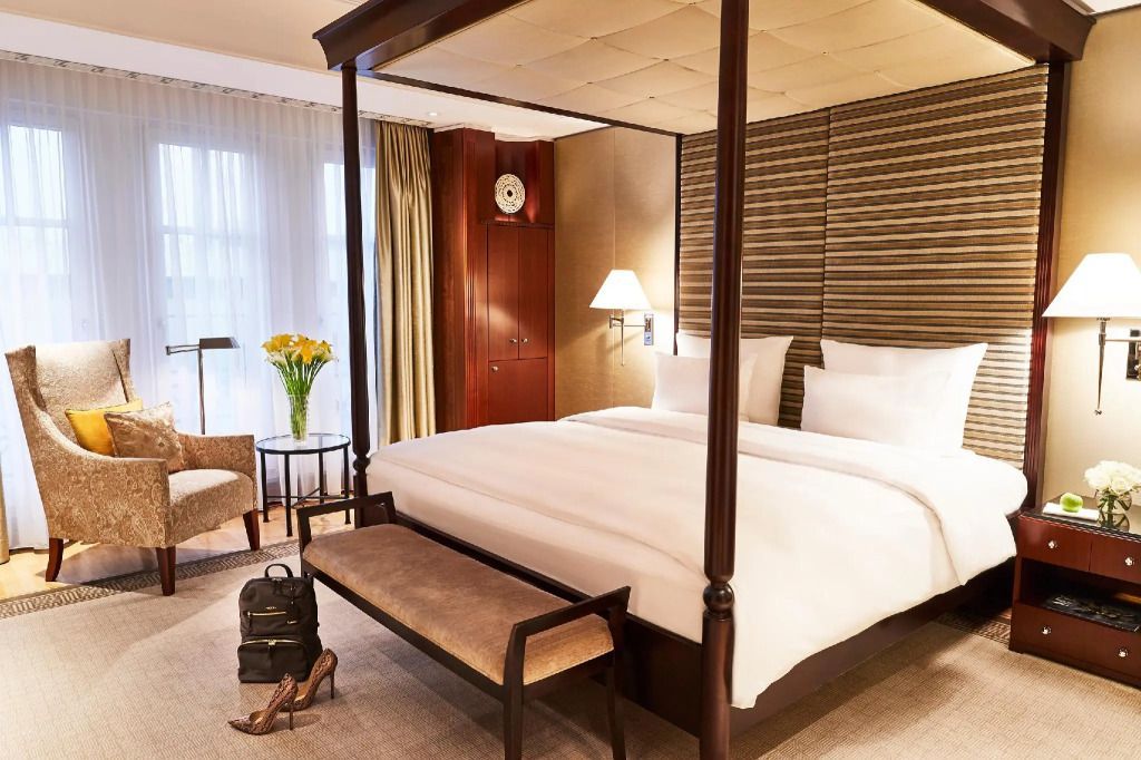 Himmelbett mit bequemen Sitzgelegenheiten in der Linden Suite des Hotel Adlon Kempinski Berlin