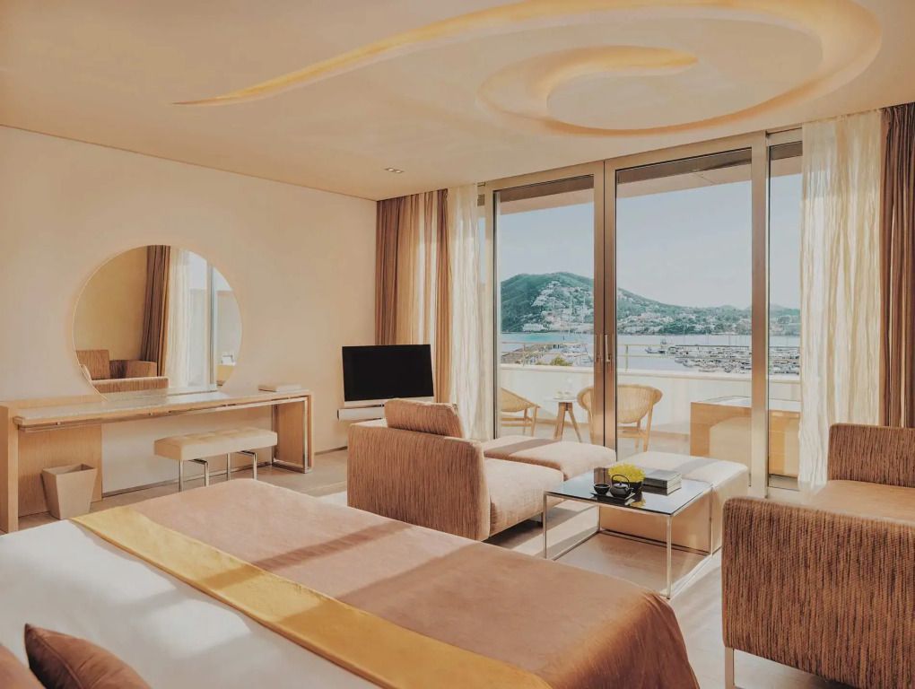 Helles Zimmer mit großem Fenster und Blick auf das Meer in der Cloud 9 Suite